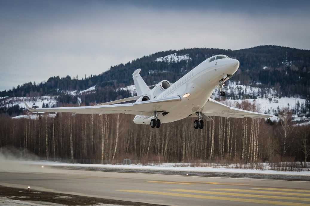 Business jet flying low above a snow-covered runway